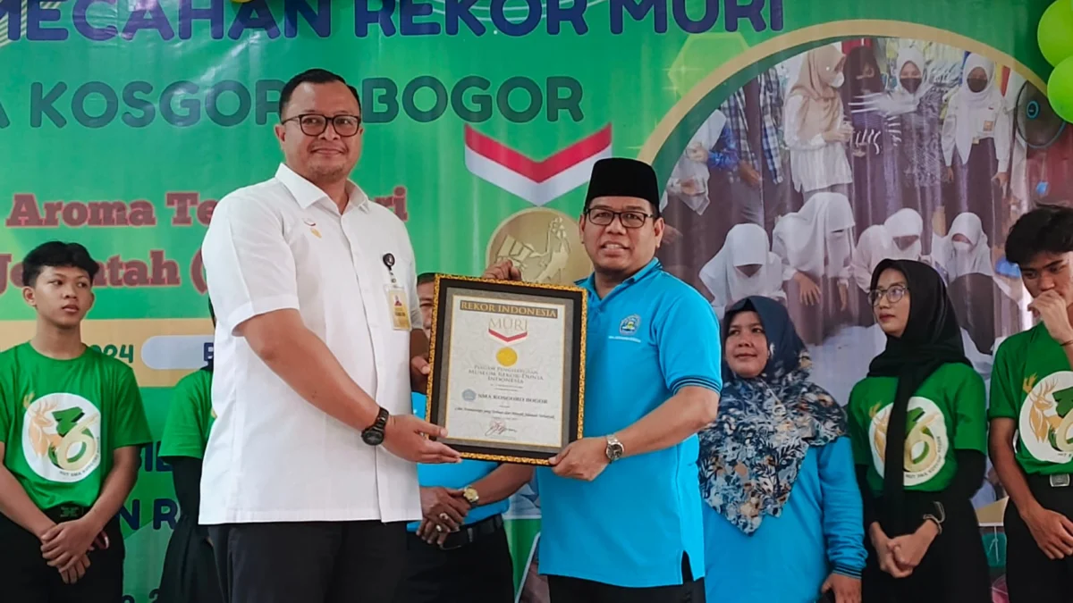 Ciptakan 4053 Lilin dari Limbah Minyak Jelantah, SMA Kosgoro Kota Bogor Pecahkan Rekor Muri Kepala SMA Kosgoro Kota Bogor, Herman Lasrin (Kanan) saat menerima Piagam Penghargaan Rekor MURI atas karya siswa-siswinya, Rabu (31/7). (Yudha Prananda / Jabar Ekspres)