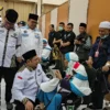Sekjen Kemenag dan para penyelenggara inadah haji dan umrah saat menyambut kedatangan jemaah haji kloter terakhir di Asrama Haji Bekasi, Minggu (21/7/2024). (Dok. Kemenag RI)