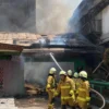 Para petugas pemadam kebakaran tengah memadamkan api yang melahap dua bangunan madrasah, di Babakan Ciparay, Kota Bandung, Minggu (27/7). (Nizar/Jabar Ekspres)