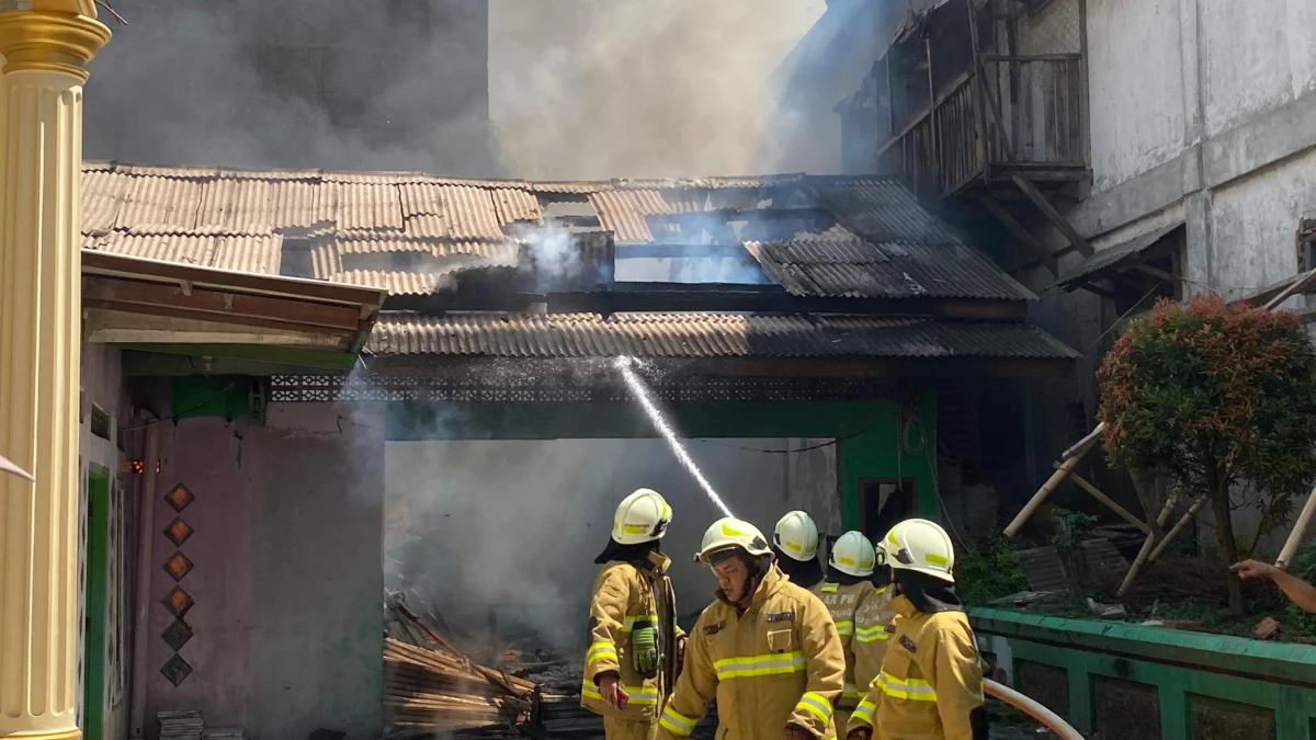 Para petugas pemadam kebakaran tengah memadamkan api yang melahap dua bangunan madrasah, di Babakan Ciparay, Kota Bandung, Minggu (27/7). (Nizar/Jabar Ekspres)
