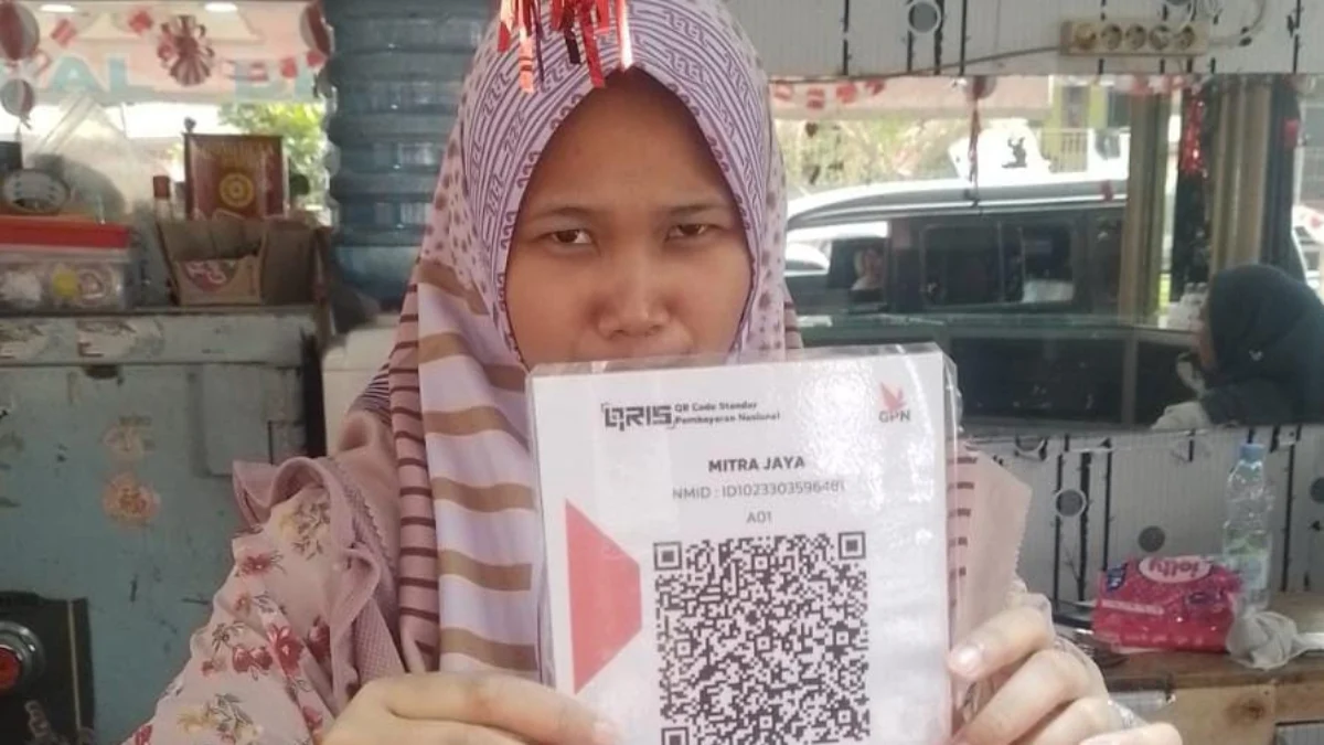 Keren! Kini Pengunjung Pasar Cigombong Bogor Bisa Bayar Pakai QRIS Pedagang di Pasar Cigombong saat menunjukan barcode pembayaran dengan QRIS. Foto : Istimewa