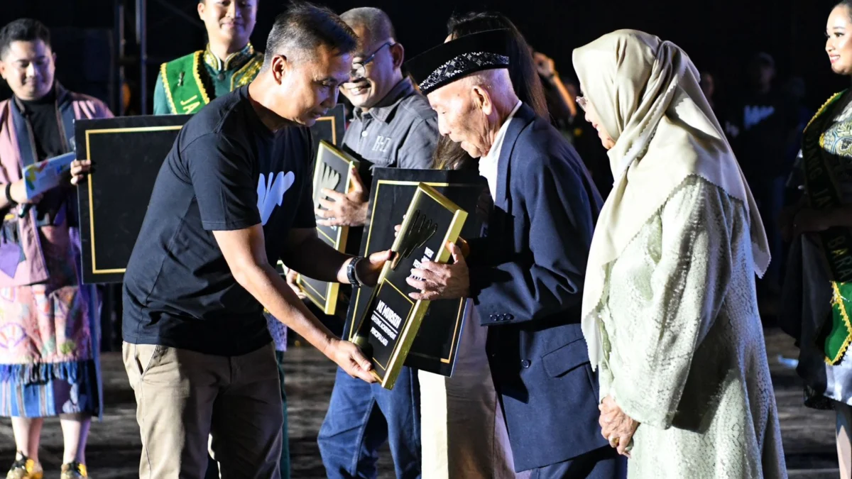 Penjabat (Pj.) Gubernur Jabar Bey Machmudin menyerahkan penghargaan lifetime achievement dalam malam puncak konser West Java Festival 2024 di Lapangan Saparua, Kota Bandung, pada Minggu (25/8/2024) malam WIB.