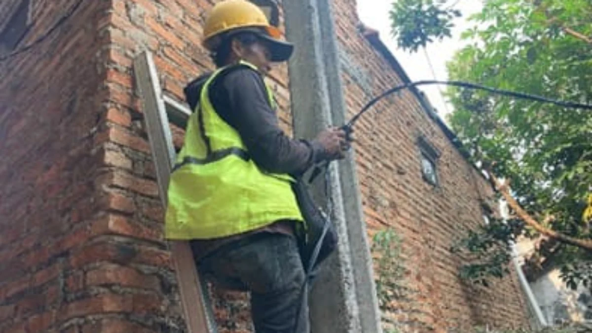 Tingkatkan Keamanan Lingkungan, Pemkot Cimahi Tambah 615 Titik Penerangan Jalan Doc. Seorang Petugas Sedang Memasang Kabel Penerangan di Sejumlah Gang di Kota Cimahi (Istimewa)
