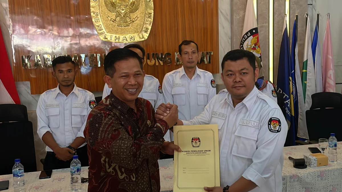 Ketua KPU Bandung Barat, Ripqi Ahmad Sulaeman saat menyerahkan SK penetapan lolos verfak pasangan Sundaya-Aa Maulana di Kantor KPU KBB. Senin (19/8). Dok Jabar Ekspres