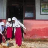 Sejumlah siswa SD membersihkan lumpur pasca banjir di Muaro Jambi. (foto/ANTARA)