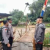 PIhak kepolisian saat mengecek kondisi jembatan yang menghubungkan dua desa Pacet dan Majalaya terputus akibat derasnya debit air anak sungai citarum. Foto Istimewa