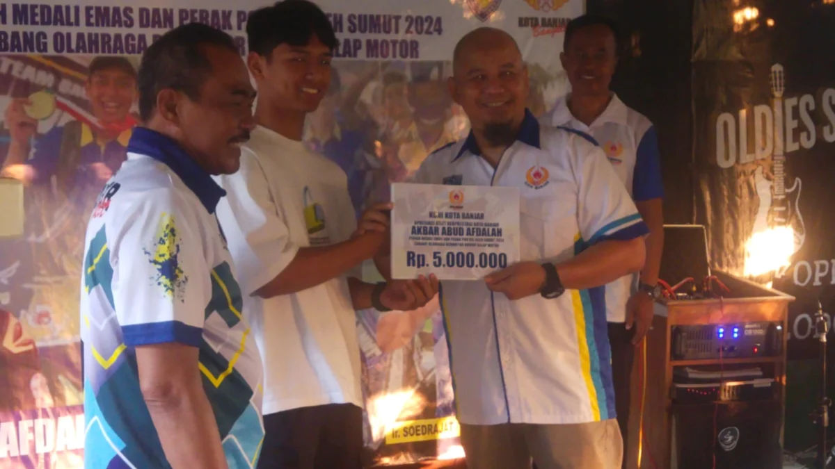 Ketua Koni Kota Banjar Ir Soedrajat Argadireja (kanan) memberikan bonus uang kadeudeuh kepada Akbar Abud Abdalah, atlet cabang olahraga (Cabor) Bermotor dari Kontingen Jawa Barat dalam Pekan Olahraga Nasional (PON) XXI Aceh Sumut 2024. (Istimewa)