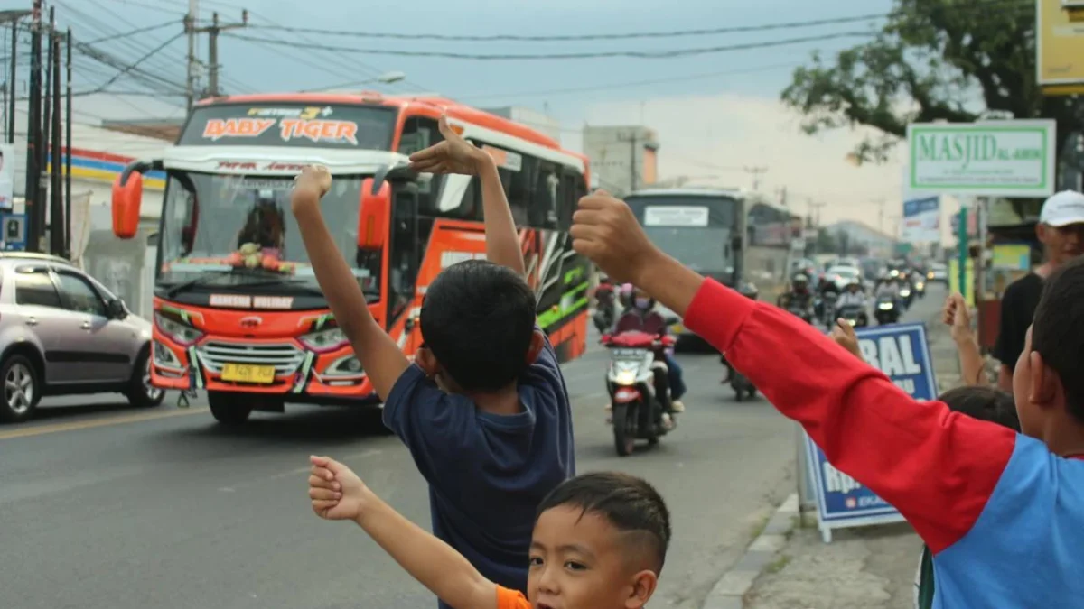 Warga Sekitar Al-Jabbar Terganggu Kebisingan Bus Telolet, Polisi Lakukan Tilang di tempat Foto ilustrasi : Anak-anak terlihat meminta para supir bus untuk membunyikan klakson telolet (Jabar Ekspres)