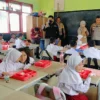 Jajaran Polres Cimahi dan Kodim 0609 Cimahi saat memberikan makan siang gratis di SD Negeri 3 Cipatat, Bandung Barat. Kamis (24/10). Dok Jabar Ekspres