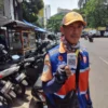 Petugas parkir yang dilengkapi barcode QRIS di Jalan ABC Kota Bandung.
