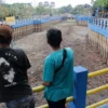 Warga sekitar tengah berada di sekitar kawasan kolam retensi Gedebage, Pasar Induk Gedebage, Kota Bandung. (Dok. Jabar Ekspres)