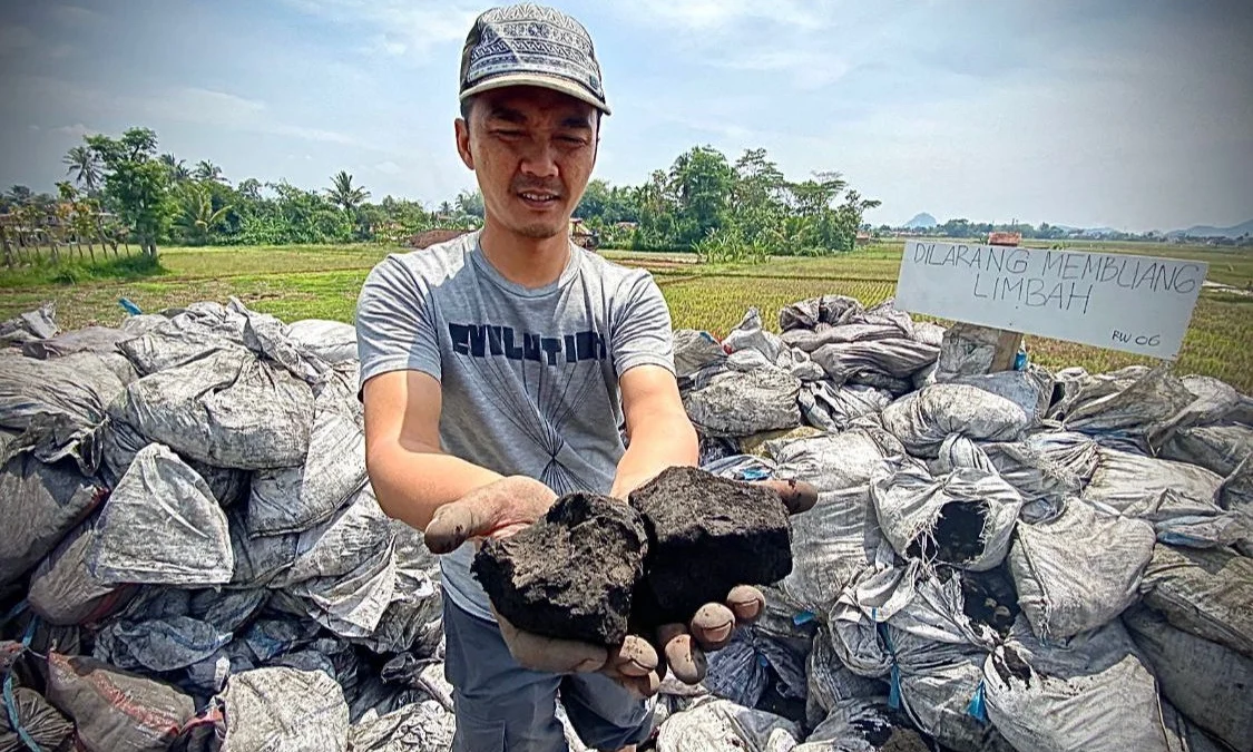 DLH Bandung Barat Tunggu Kajian Polda Jabar Soal Limbah B3 Cemari Wilayah Cihampelas Salah satu warga saat memperlihatkan limbah hasil pembakaran batu bara di Jalan Irigasi, Kampung Rongga, Desa/Kecamatan Cihampelas. Dok Jabar Ekspres
