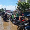 Masyarakat saat melintas Jalan Raya Dayeuhkolot yang tergenang banjir pada Kamis (21/11). Foto Agi
