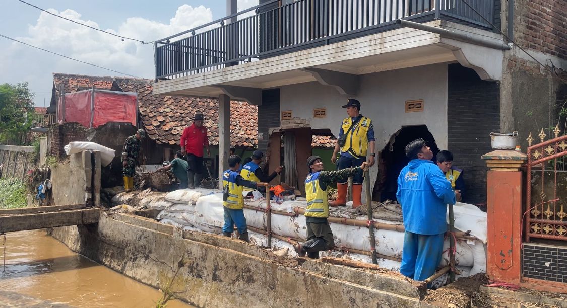 Sempat Terbawa Arus, Ini Kronologis Tanggul Jebol di Kabupaten Bandung Menurut Warga Petugas saat memperbaiki tanggul yang jebol di dekat rumah Noval yang hancur oleh aliran deras sungai. (Agi / Jabar Ekspres)