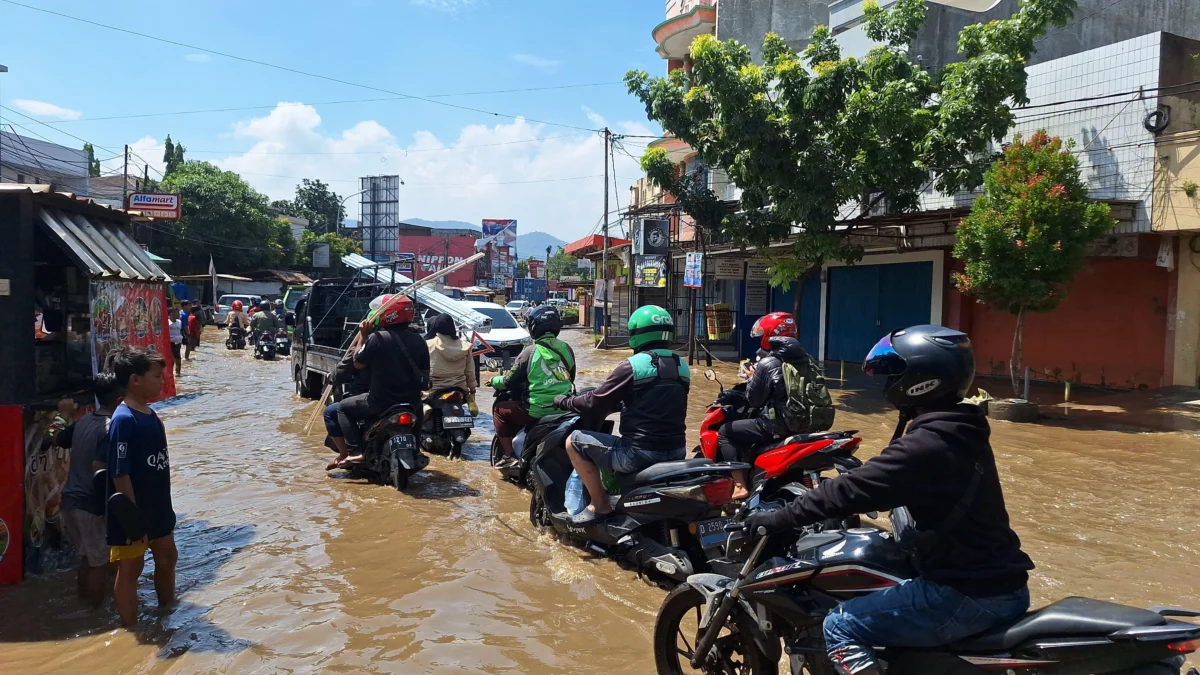 Banjir Genangi Dayeuhkolot Bandung, Kapolsek Sebut Akses Jalan Jadi Terhambat Sejumlah pengendara motor terhambat saat melintas Jalan Raya Dayeuhkolot akibat tergenang banjir. (Agi/Jabar Ekspres)
