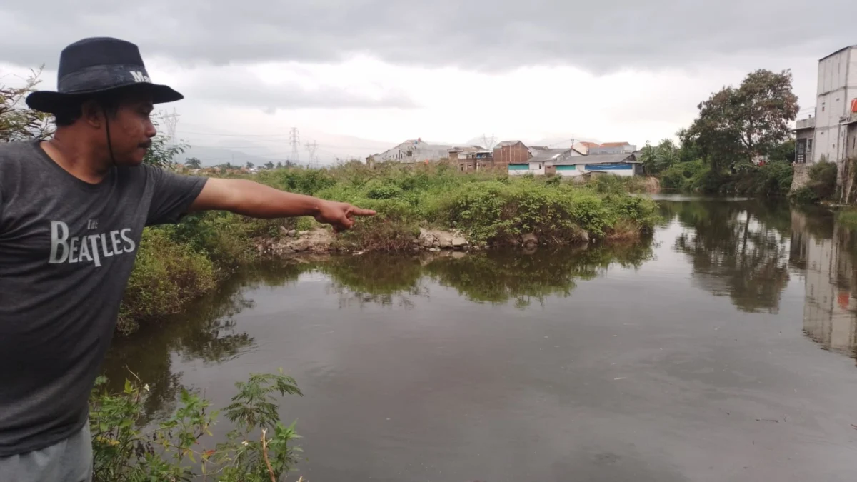 Pria Tanpa Identias Ditemukan Tak Bernyawa di Rancaekek Bandung, Mengapung di Sungai Cimande Saksi mata yang juga Ketua RW13 Desa Nanjungmekar, Junaedi saat menunjukkan TKP penemuan jenazah pria tanpa identitas di Sungai Cimande, Kecamatan Rancaekek, Kabupaten Bandung. (Yanuar/Jabar Ekspres)