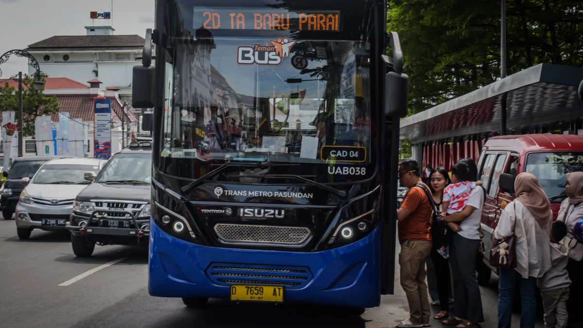 Sejumlah penumpang berjalan menaiki bus Damri di Halte Alun-Alun Bandung, Kota Bandung, Jum'at (27/12). Foto: Dimas Rachmatsyah/Jabar Ekspres
