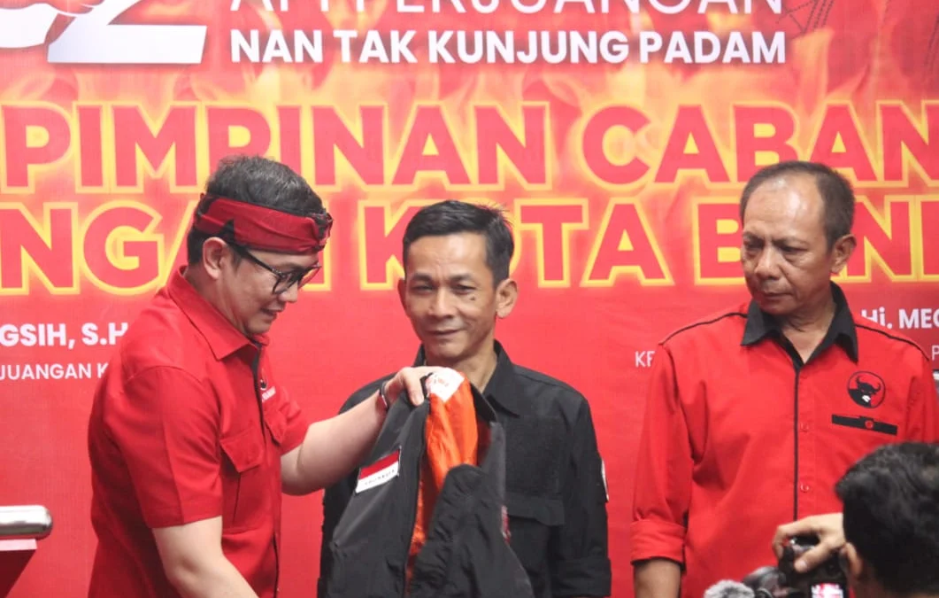 Cap Jempol Darah, PDI Perjuangan Bandung Dukung Bu Mega jadi Ketum Lagi Ketua DPC PDI Perjuangan Kota Bandung Andri Gunawan (kiri) saat menyematkan jaket satgas kepada kader militan. (Son / Jabar Ekspres)