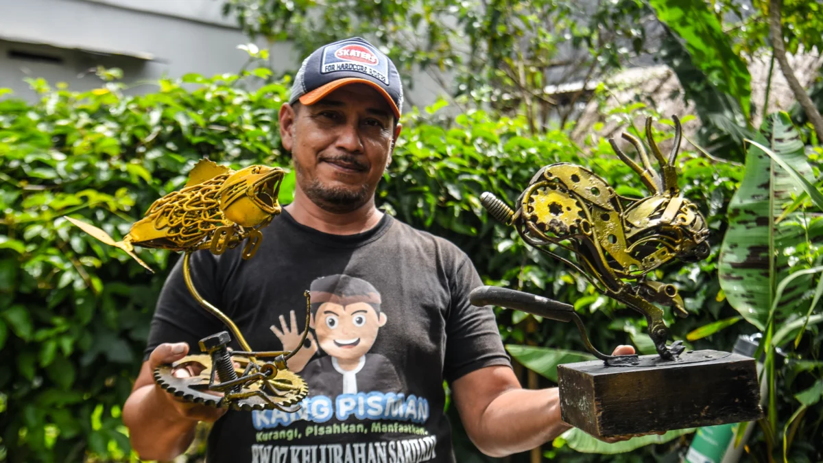 Erwin (49) pegiat lingkungan sekaligus pengurus Komunitas Baraya Sabar merangkai sampah residu untuk dijadikan karya seni di Sarijadi, Kota Bandung, Kamis (23/1). Foto: Dimas Rachmatsyah / Jabar Ekspres