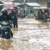 Warga melintasi banjir yang menggenangi jalan raya Dayeuhkolot - Banjaran di Kabupaten Bandung, Sabtu (25/1). Foto: Dimas Rachmatsyah / Jabar Ekspres