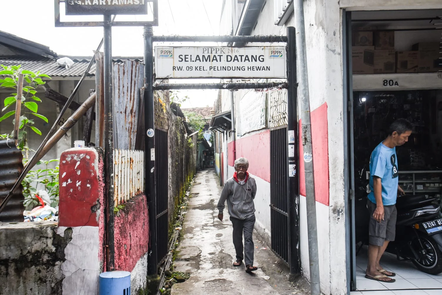 Seorang warga berjalan di Gang Karyamas l, Jl. Moh Toha, Kota Bandung, pada (31/1) sore. Foto: Dimas Rachmatsyah / Jabar Ekspres