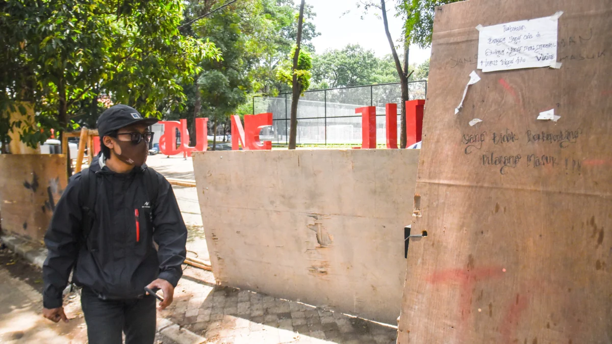Ilustrasi: Warga berjalan di dekat proyek renovasi taman di Lapangan Supratman, Kota Bandung, Jum'at (17/1). Pemerintah Kota Bandung merenovasi beberapa taman yang ada di Kota Bandung salah satunya berlokasi di taman lapangan Supratman. Foto: Dimas Rachmatsyah / Jabar Ekspres