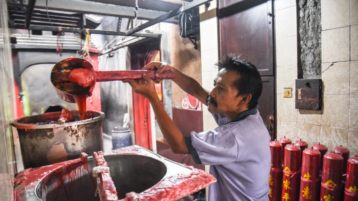 Pekerja menyelesaikan pembuatan lilin berukuran besar di Vihara Dharma Ramsi, Gang Ibu Aisah, Jalan Cibadak, Kota Bandung, Senin (20/1). Jelang Tahun Baru Imlek yang jatuh pada 29 Januari 2025, Vihara Dharma Ramsi membuat ratusan lilin merah berbagai ukuran untuk kebutuhan beribadah warga keturunan Tionghoa. Lilin merah tersebut dibuat sejak beberapa bulan sebelumnya dengan berbagai ukuran 25 kati, 50 kati, 100 kati, hingga 200 kati. Lilin-lilin berukuran besar ini merupakan pesanan yang sudah ditempel doa-doa dan nantinya akan ditata di halaman vihara dan akan dinyalakan pada perayaan malam tahun baru imlek. Foto: Dimas Rachmatsyah / Jabar Ekspres