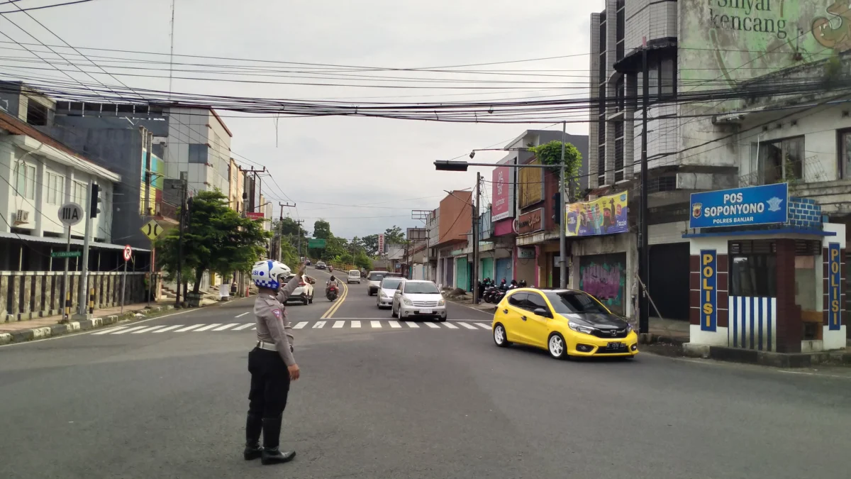 Seorang petugas Satlantas Polres Banjar mengatur arus lalu lintas secara manual, lantaran lampu pengatur di perempatan jalan Letjen Soewarto tersebut tidak berfungsi, Kamis 30 Januari 2025. (Cecep Herdi/Jabar Ekspres)