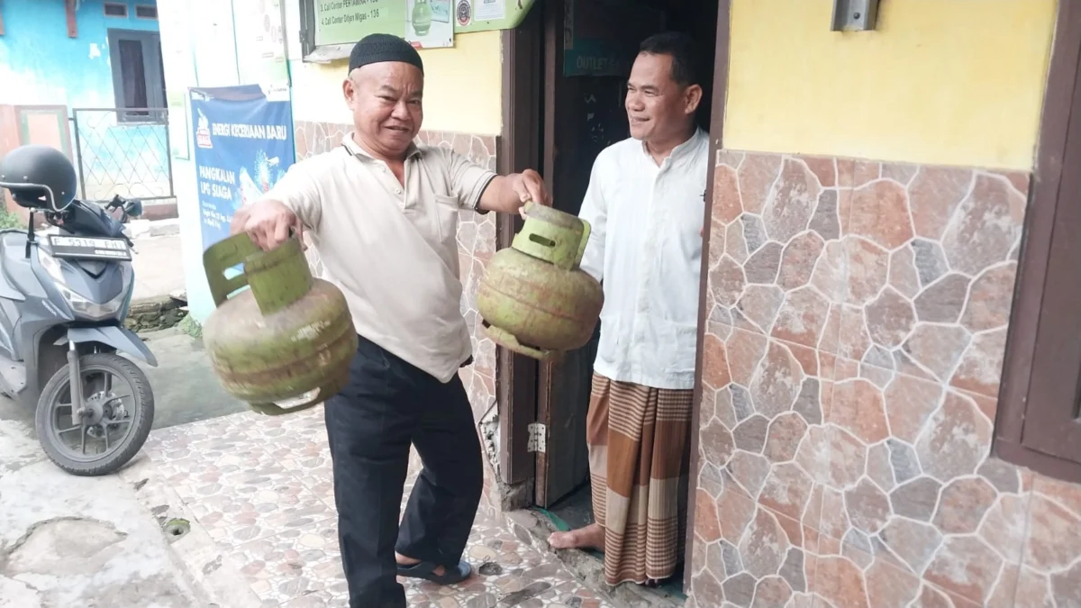 Yusup saat sedang memberikan gas elpiji 3 Kg kepada pembeli, Jumat (31/1). Foto : Regi