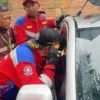 Tim Rescue Dinas Pemadam Kebakaran dan Penyelamatan Kabupaten Bandung dengan saat proses evakuasi anak usia 3 tahun yang terjebak di dalam mobil. (Disdamkar Kabupaten Bandung for Jabar Ekspres)
