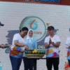 Direktur Medis & Hubungan Kelembagaan Bio Farma, Sri Harsi Teteki beserta Ketua Forum Jawa Barat Sehat, Atalia Praratya (tengah) di kegiatan pemotongan tumpeng pada acara Fun Run “Enam Tahun Dedikasi – Solution to Immunity” HUT Immunicare ke – 6