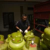 Petugas menurunkan tabung gas elpiji 3 kg dari mobil pikap di salah satu pangkalan elpiji di kawasan Jalan Suryani, Kota Bandung, Senin (3/1). Foto: Dimas Rachmatsyah / Jabar Ekspres