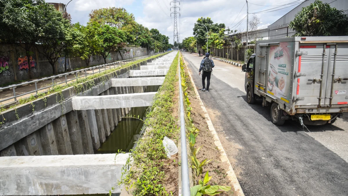 Seorang warga berjalan di samping kolam retensi Gedebage, Kota Bandung. Foto: Dimas Rachmatsyah / Jabar Ekspres