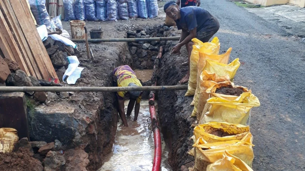 Petugas Perumdam Tirta Anom memperbaiki pipa utama jaringan air bersih yang bocor saat pelaksanaam uji alir baru-baru ini. (Foto Istimewa)