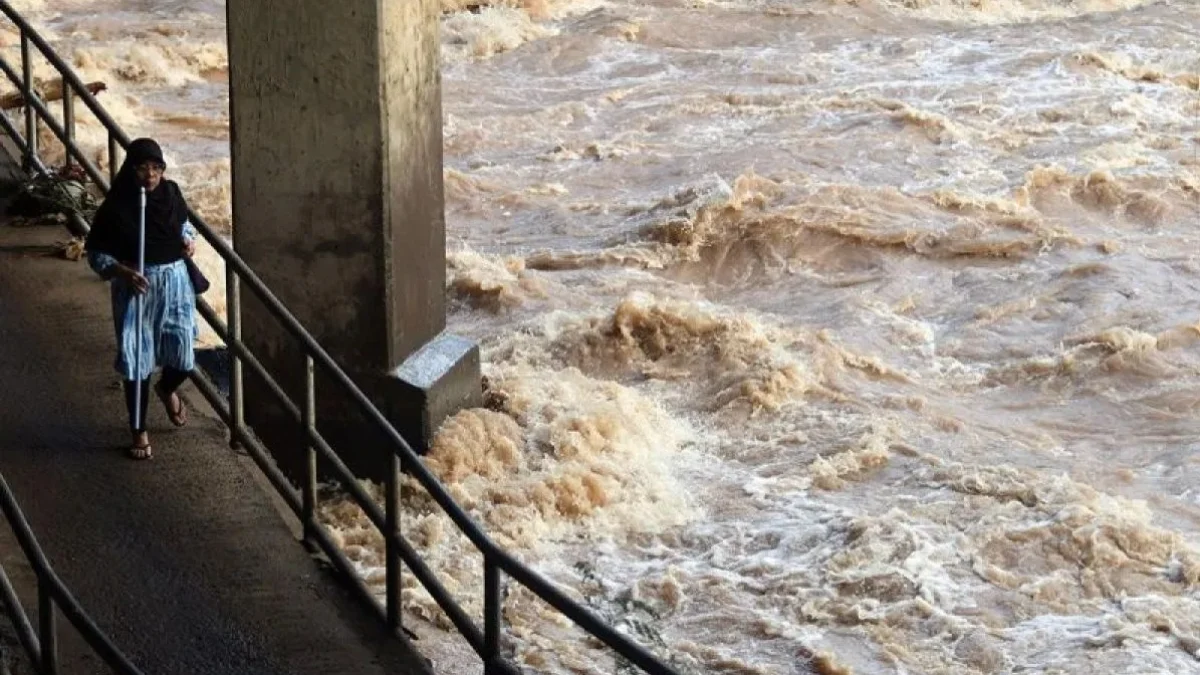 Seorang warga melintas di jembatan Sungai Ciliwung. (foto/ANTARA)