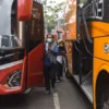 Calon penumpang berjalan menuju bus di Terminal Cicaheum, Kota Bandung, Senin (24/3). Foto: Dimas Rachmatsyah / Jabar Ekspres
