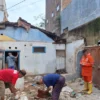 Petugas BPBD Bandung Barat dibantu warga saat mengevakuasi material rumah hancur akibat bencana. Dok BPBD KBB