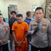 Terduga pelaku kasus pengurangan MinyaKita, TRM, tertunduk saat dihadirkan dalam press release, Senin (10/3). Foto: Sandika / Jabar Ekspres