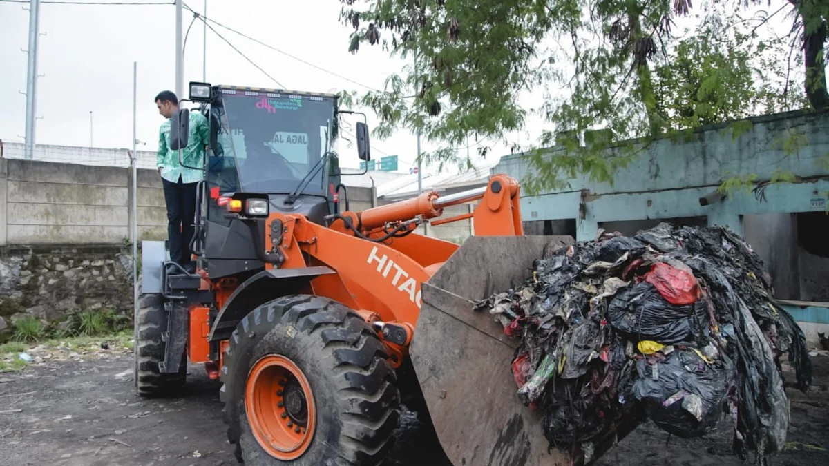 Wakil Bupati Bandung, Ali Syakieb saat pimpin langsung operasi bersih gunungan sampah di Pasar Cileunyi, Kabupaten Bandung menaiki truck backhoe. Foto Istimewa