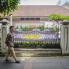 Seorang warga berjalan di dekat spanduk bertuliskan "SAVESMANSABANDUNG" di depan SMA Negeri 1, Kota Bandung, Jum'at (21/3). Foto: Dimas Rachmatsyah / Jabar Ekspres