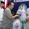 Ketua DPRD Kota Bogor, Adityawarman Adil secara simbolis memberikan santunan kepada anak yatim di acara Bukber dan Santunan PWI Kota Bogor. (Foto: Humpro DPRD Kota Bogor)