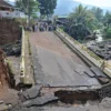 Kondisi jembatan penghubung Desa Leuwimalang dan Desa Jogjogan yang amblas akibat luapan Sungai Ciliwung. Foto: Sandika / Jabar Ekspres