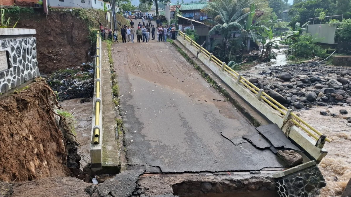 Kondisi jembatan penghubung Desa Leuwimalang dan Desa Jogjogan yang amblas akibat luapan Sungai Ciliwung. Foto: Sandika / Jabar Ekspres