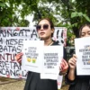 Mahasiswa memegang poster tuntutan saat aksi protes terkait pelarangan pertunjukan monolog Wawancara dengan Mulyono oleh Teater Payung Hitam di Taman Kampus ISBI, Kota Bandung, (17/2). Foto: Dimas Rachmatsyah / Jabar Ekspres