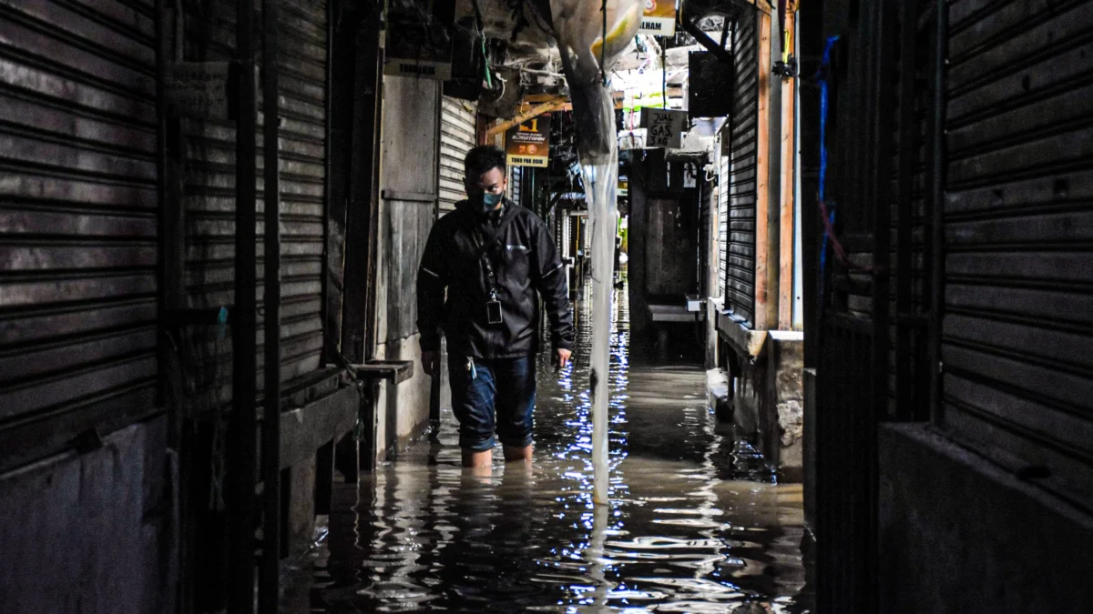 Ilustrasi: Warga melintasi genangan banjir di salah satu Pasar beberapa waktu lalu. Foto: Dimas Rachmatsyah / Jabar Ekspres