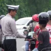 Salah satu anggota Satlantas Polres Banjar saat memberikan takjil kepada salah satu pengendara bermotor di jalan raya kota Banjar, Rabu (5/3/3025).