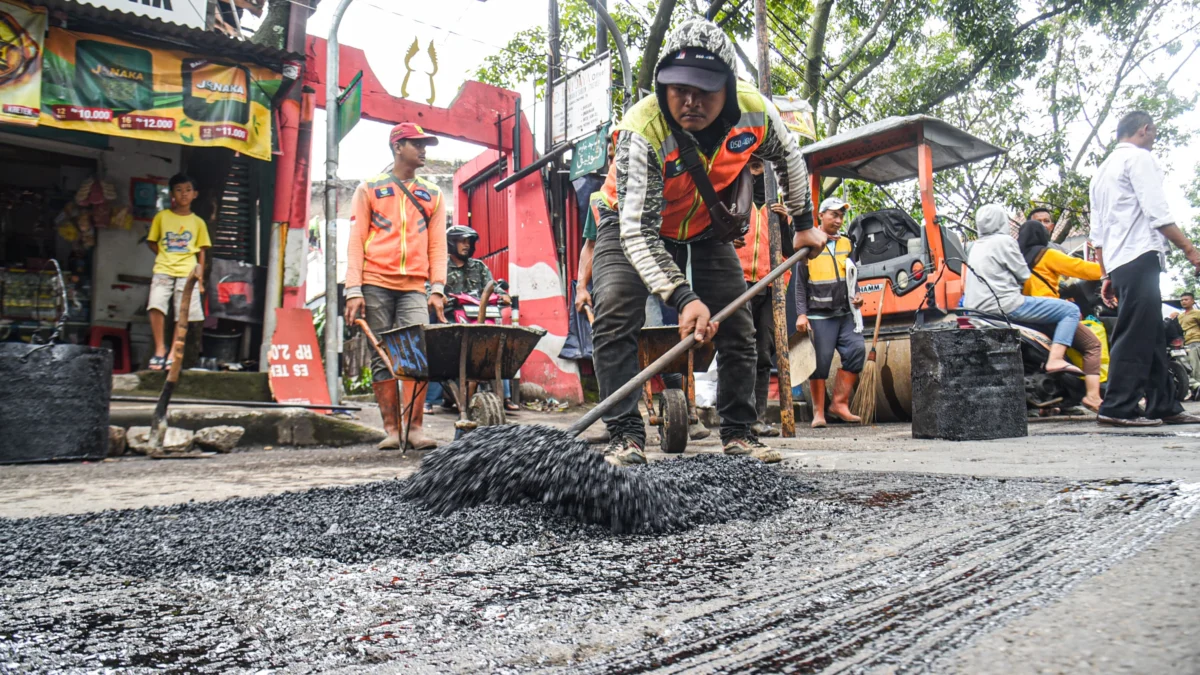 Ilustrasi: Petugas memperbaiki jalan berlubang di Jalan Ibrahim Adjie, Kota Bandung, beberapa waktu lalu. Foto: Dimas Rachmatsyah / Jabar Ekspres