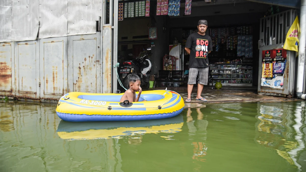 Pasca Banjir Landa 13 Kecamatan dan 33 Desa, Pemkab Bandung Tetapkan Status Tanggap Darurat 14 Hari Seorang anak bermain di depan rumahnya yang terendam banjir di Kampung Cijagra, Bojongsoang, Kabupaten Bandung, Minggu (9/3). Foto: Dimas Rachmatsyah / Jabar Ekspres