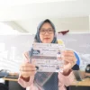Seorang warga menunjukan voucher mudik gratis di Jembatan Penyeberangan Orang (JPO) Asia Afrika, Kota Bandung, Rabu (12/3). Foto: Dimas Rachmatsyah / Jabar Ekspres