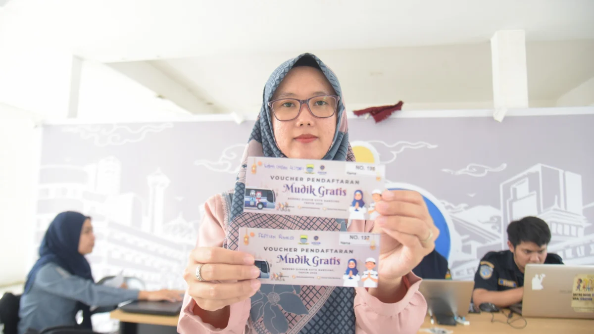 Pendaftaran Resmi Dibuka, Pemkot Bandung Siapkan 259 Kuota Mudik Gratis Lebaran 2025 Seorang warga menunjukan voucher mudik gratis di Jembatan Penyeberangan Orang (JPO) Asia Afrika, Kota Bandung, Rabu (12/3). Foto: Dimas Rachmatsyah / Jabar Ekspres